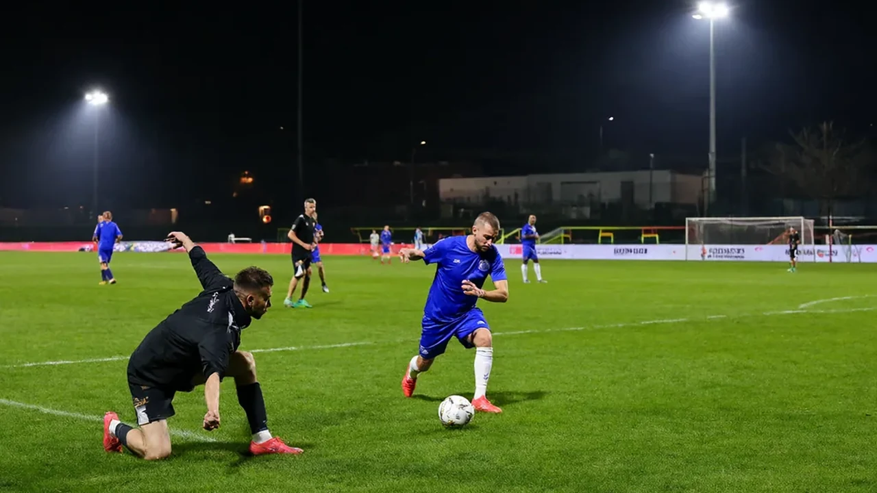 Player stretching in the closing minutes of a European night under floodlights
