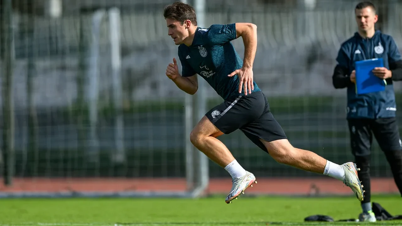 Footballer sprinting at full speed on a training pitch
