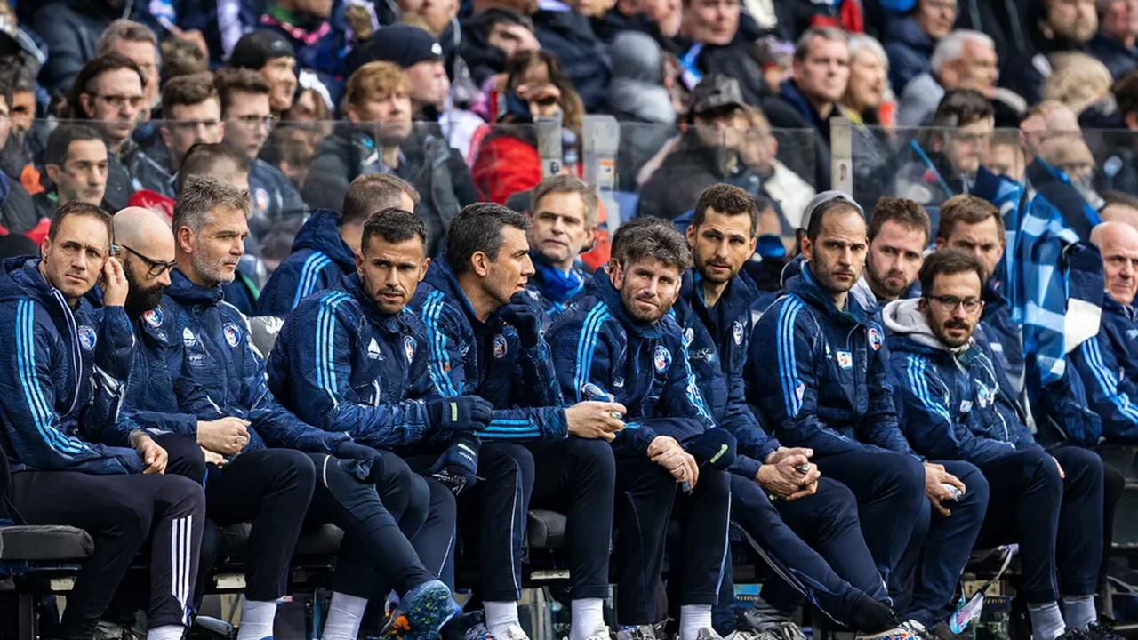 Substitutes in tracksuits watching from the bench