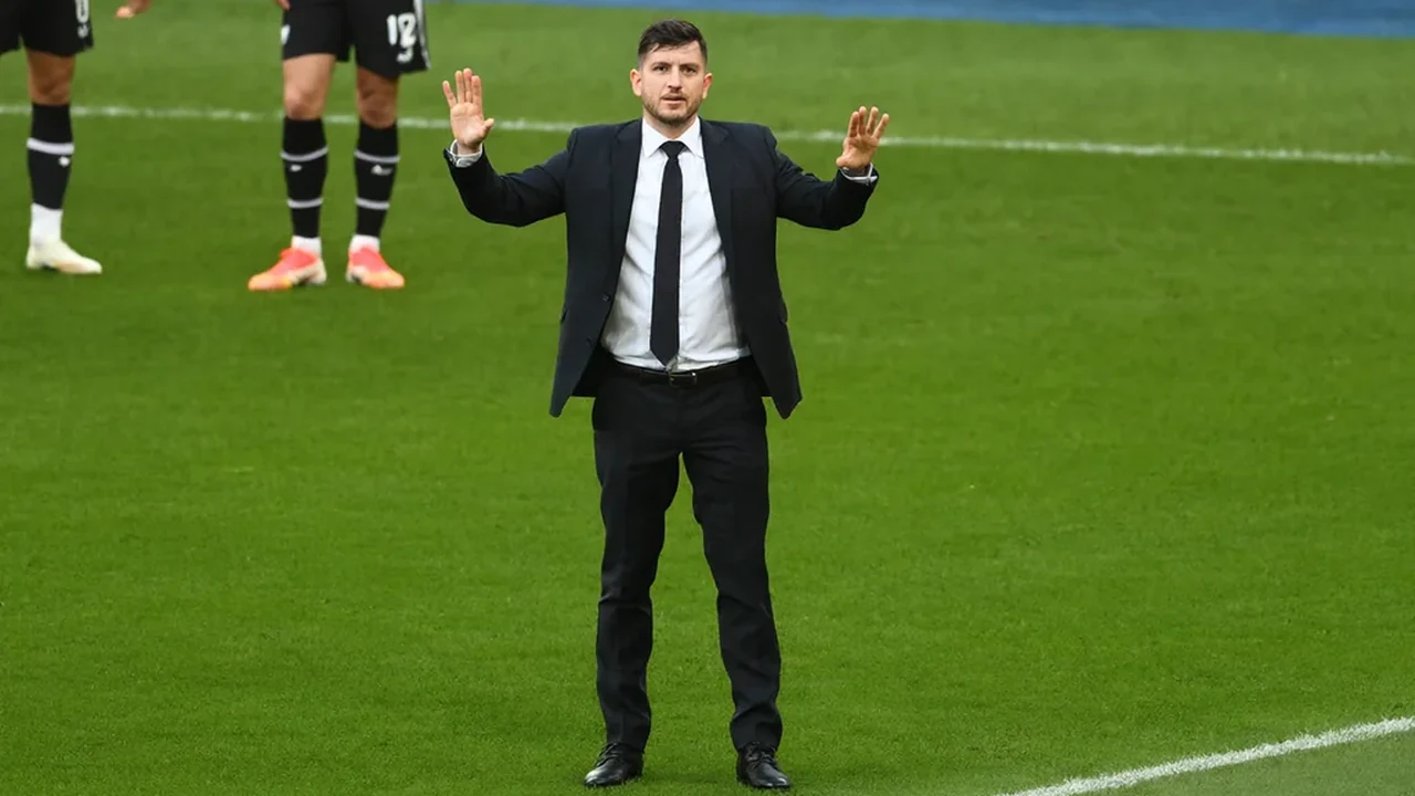 Manager gesturing from the touchline in a suit